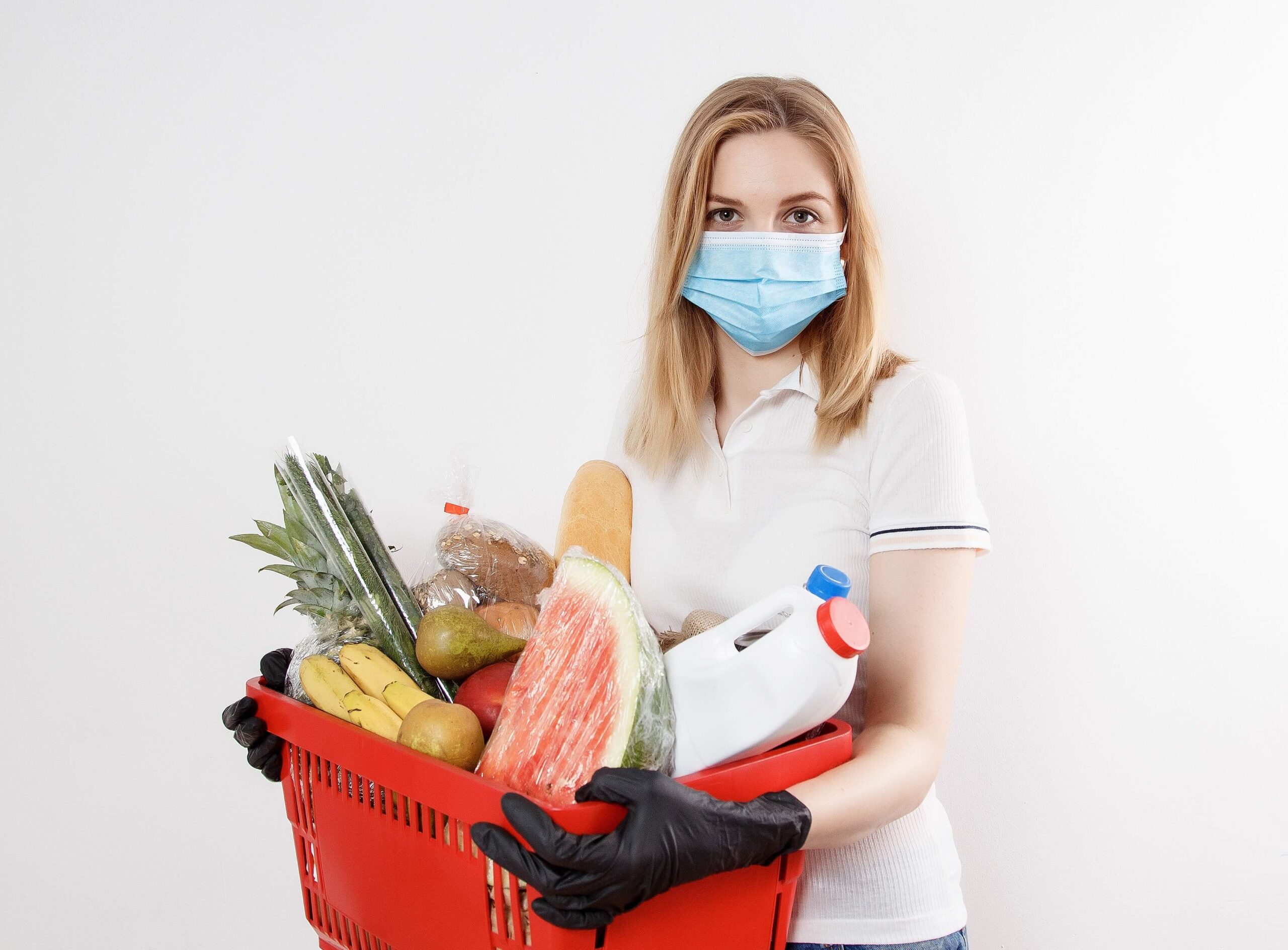 mujer con cubre bocas y productos para el hogar